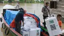 Petugas pemilu menurunkan kotak suara dari perahu saat distribusi perlengkapan pemilu ke desa-desa terpencil, di Pemulutan, Sumatra Selatan, Selasa, 13 Februari 2024. (AP Photo/Muhammad Hatta)