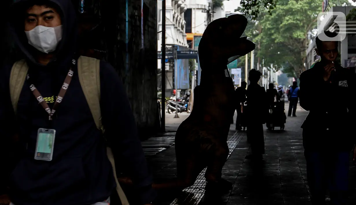Sejumlah aktivis dari People for the Ethical Treatment of Animals (PETA) menggunakan kostum dinosaurus sambil membawa poster di kawasan Dukuh Atas, Jakarta, Selasa (24/10/2023). (Liputan6.com/Angga Yuniar)