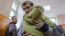 Blogger Rusia, Ruslan Sokolovsky, memeluk ibunya saat persidangan di Pengadilan Kota Yekaterinburg, Kamis (11/5). Pengadilan setempat memvonis Ruslan karena perbuatannya dianggap menghina pemeluk agama dan mengumbar kebencian. (Konstantin Melnitskiy/AFP)