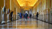 Karyawan museum berjalan menyusuri lorong Museum Vatikan saat mereka bersiap untuk buka, Vatikan, Senin (1/2/2021). Museum Vatikan kembali dibuka untuk pengunjung pada 1 Februari 2021 setelah 88 hari ditutup untuk mencegah penyebaran COVID-19. (AP Photo/Andrew Medichini)