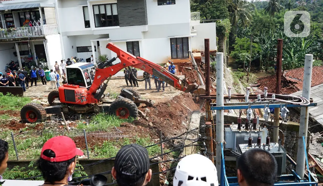 Petugas menggunakan alat berat berusaha merapikan posisi turap yang hancur di Jalan Damai, Ciganjur, Jakarta Selatan, Minggu (11/10/2020). Hujan yang deras sejak Sabtu (10/10/2020) sore mengakibatkan kawasan tersebut mengalami banjir sekaligus longsor. (Liputan6.com/Immanuel Antonius)