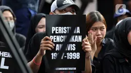 Aksi damai ini kali pertama dilakukan pada 18 Januari 2007. Tampak dalam foto, aktivis Jaringan Solidaritas Korban untuk Keadilan memegang pamflet saat mengikuti peringatan 19 tahun Aksi Kamisan di Jalan Medan Merdeka Utara atau di seberang Istana Merdeka, Jakarta, 15 Januari 2026. (Liputan6.com/Helmi Fithriansyah)
