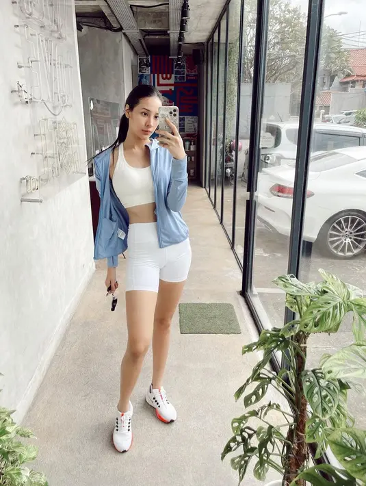 Saat nge-gym, Anya memadukan setelan baju olahraga warna putih yang dilengkapi jaket biru. Tak lupa ia mengenakan sneakers warna putih. @anyageraldine.