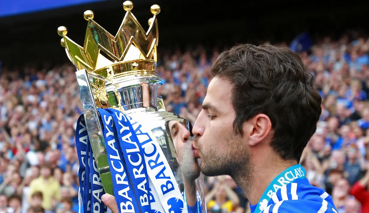Gelandang Chelsea,  Cesc Fabregas mencium trofi di tengah perayaan gelar juara Premier League 2014-15 di Stamford Bridge, Minggu (24/5/2015). Ini merupakan Gelar ke-4 Chelsea di Premier League.  (Reuters/John Marsh)