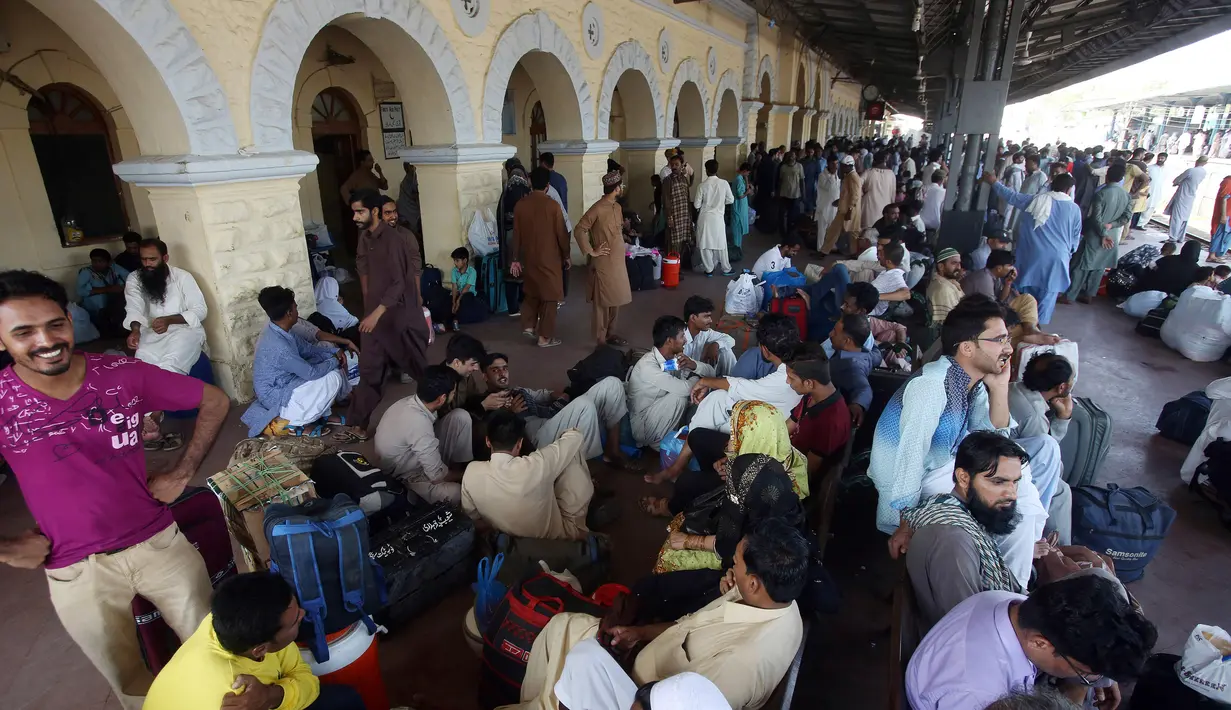 Orang-orang menunggu kereta untuk kembali ke kota asal mereka untuk liburan Idul Fitri di stasiun kereta api di Karachi, Pakistan (2/6/2019). Idul Fitri menandai akhir bulan suci Ramadan. (AP Photo/Fareed Khan)