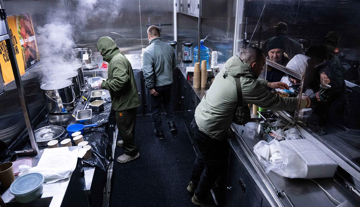 Hampir 80 persen wilayah Ukraina mengalami pemadaman listrik darurat. Tampak dalam foto, para veteran the 3rd Separate Assault Brigade Angkatan Bersenjata Ukraina menyajikan makanan panas gratis bagi orang-orang di lingkungan perumahan yang rumahnya tanpa listrik setelah serangan udara Rusia berulang kali terhadap sektor energi negara itu di Kyiv, Selasa 27 Januari 2026. (AP Photo/Danylo Antoniuk)