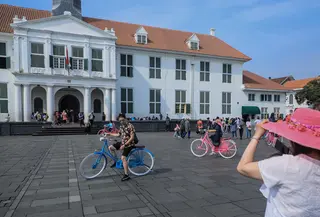 Wisatawan berfoto dengan latar belakang Museum Fatahillah di kawasan Kota Tua, Jakarta, Sabtu (8/6/2019). Selama libur lebaran 2019, jam berkunjung ke berbagai museum di kawasan wisata sejarah Kota Tua diperpanjang hingga pukul 20.00 WIB. (Liputan6.com/Faizal Fanani)