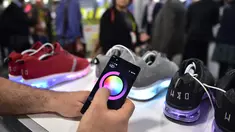 Pengunjung mencoba memprogram lampu sepatu Wize & Ope di Consumer Electronic Show (CES), Las Vegas (5/1). Dengan program dari smartphon, lampu pada bagian bawah sepatu Wize & Ope dapat dinyalakan. (AFP Photo/Frederic J. Brown)