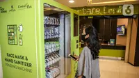 Pengunjung melihat vending machine penjual masker di mal Central Park, Jakarta, Kamis (11/6/2020). Selain menerapkan protokol kesehatan ketat, pusat perbelanjaan juga menyediakan fasilitas pendukung 'physical distancing' sebagai persiapan operasional di era normal baru. (Liputan6.com/Faizal Fanani)