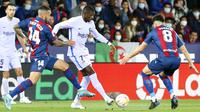 Pemain Barcelona Ousmane Dembele berebut bola dengan pemain Levante Ruben Vezo dan Pepelu (kanan) pada pertandingan sepak bola La Liga Spanyol di Stadion Ciutat de Valencia, Valencia, Spanyol, 10 April 2022. Barcelona menang 3-2. (AP Photo /Alberto Saiz)