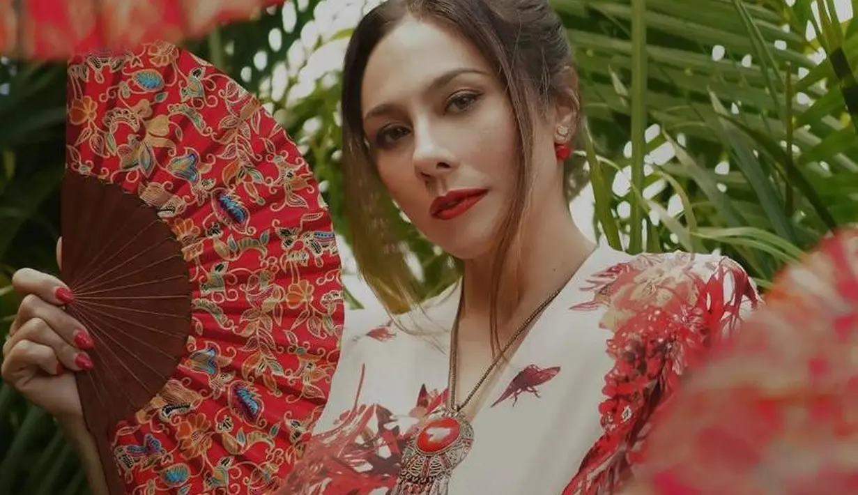 Rambutnya ditata cepol ke atas dengan menyisakan beberapa poni yang membingkai wajahnya. [@theomono/@wulanguritno].