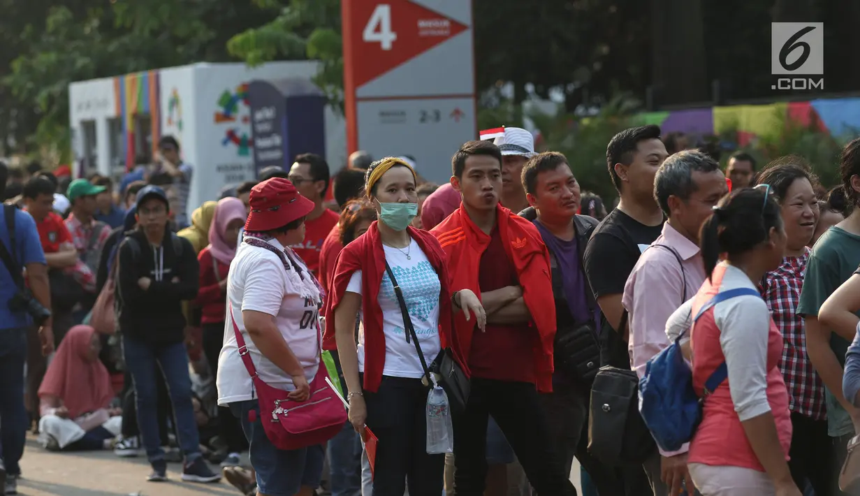 Antrean calon penonton untuk mendapatkan tiket final bulu tangkis beregu putra di sekitar tiket boks di kawasan GBK, Jakarta, Rabu (22/8). Laga final bulu tangkis beregu putra mempertemukan Indonesia melawan China. (Liputan6.com/Helmi Fithriansyah)