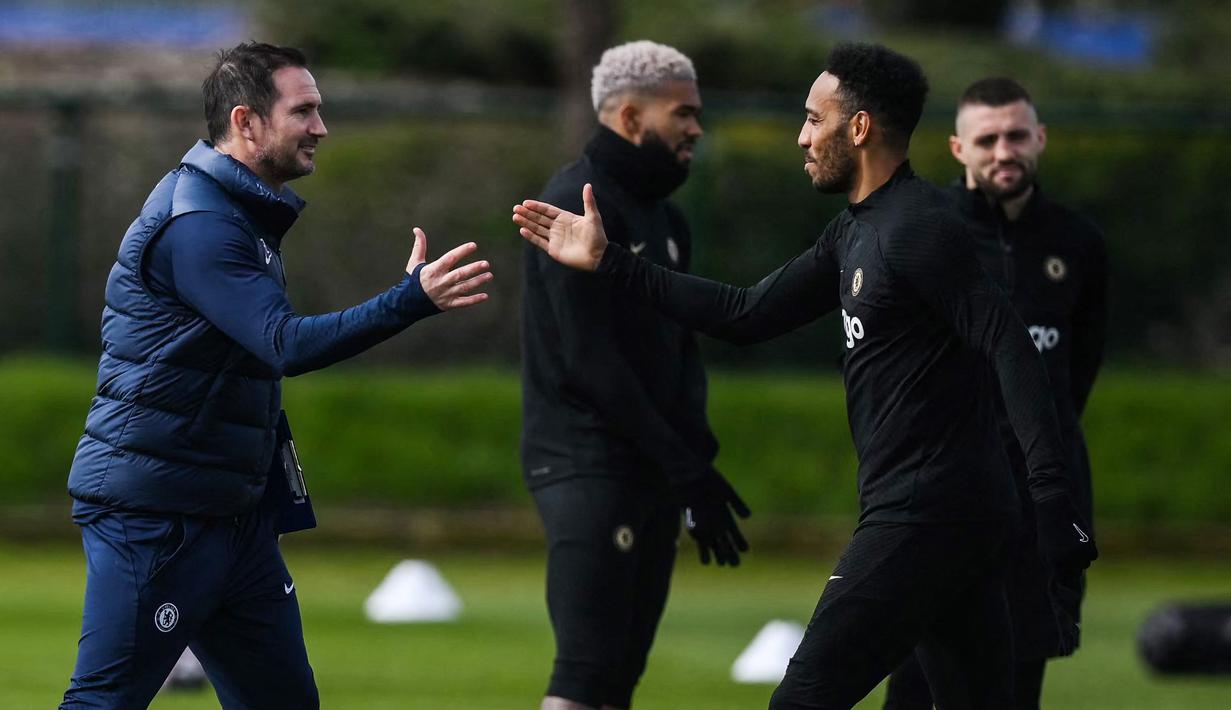 Pelatih Chelsea, Frank Lampard, bersalaman dengan Pierre-Emerick Aubameyang, saat sesi latihan jelang laga Liga Champions melawan Real Madrid di London, (11/4/2023). Frank Lampard memotivasi skuadnya agar tampil totalitas dan meraih kemenangan di Santiago Bernabeu. (AFP/Daniel Leal)