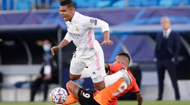 Gelandang Real Madrid, Casemiro berebut bola dengan gelandang Shakhtar Donetsk, Dentinho pada pertandingan pertama Liga Champions Grup B di Stadion Alfredo Di Stefano, Kamis dinihari WIB (22/10/2020). Real Madrid ditaklukkan Shakhtar Donetsk 3-2.  (AP Photo/Manu Fernandez)