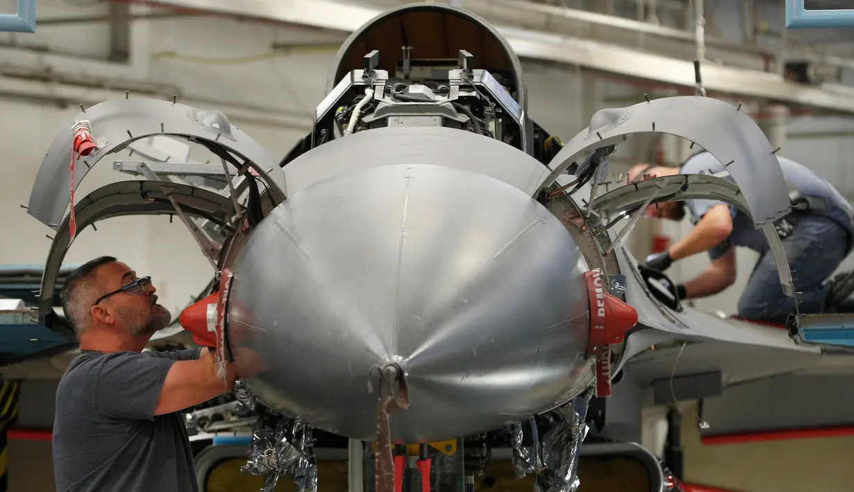 Mekanik pesawat terbang melakukan perbaikan pesawat F-16 Falcon di pangkalan Angkatan Udara Hill di Ogden, Utah (20/12). Di pangkalan udara ini jet temput A-10 dan F-16 dilakukan perbaikan dan diperiksa kesiapannya. (George Frey/Getty Images/AFP)