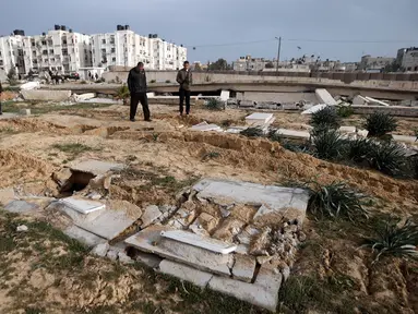 Warga Palestina memeriksa pemakaman yang rusak menyusul serangan tank Israel di pemakaman di kamp pengungsi Khan Younis, Jalur Gaza selatan, Rabu (17/1/2024). (AP Photo/Mohammed Dahman)