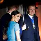 Meghan Markle memegang lengan Pangeran Harry yang memayunginya saat tiba di Endeavour Fund Awards, London, Inggris, Kamis (5/3/2020). Meghan Markle memilih tampil dengan dress rancangan Victoria Beckham. (AP Photo/Kirsty Wigglesworth)