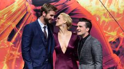 (Kiri-kanan) Aktor Liam Hemsworth, aktris Jennifer Lawrence dan aktor Josh Hutcherson berpose untuk fotografer saat menghadiri pemutaran perdana film "The Hunger Games : Mockingjay Part 2" di Berlin, Jerman, Rabu (4/11). (AFP PHOTO/JOHN MacDougall)