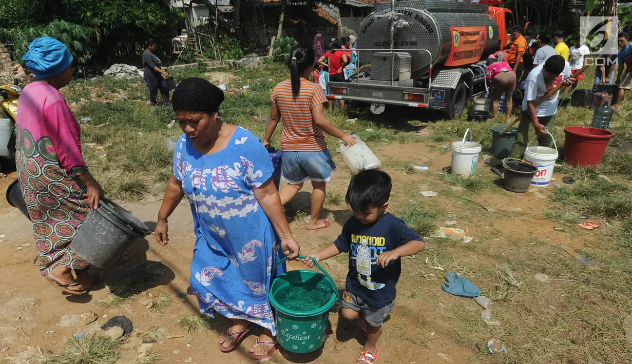 Warga membawa air bersih bantuan Badan Penanggulangan Bencana Daerah (BPPD) Kabupaten Bogor di Pabuaran, Ciampea, Bogor, Jawa Barat, Senin (6/8). Kemarau menyebabkan sejumlah wilayah kekeringan dan kesulitan air bersih. (Merdeka.com/Arie Basuki)