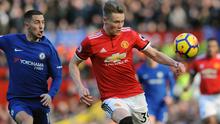 Pemain Manchester United, Scott McTominay berebut bola dengan pemain Chelsea, Eden Hazard pada laga pekan ke-28 Premier League, di Old Trafford, Minggu (25/2). Manchester United menuai kemenangan tipis 2-1 atas Chelsea. (AP/Rui Vieira)