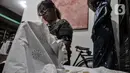 Perajin menyelesaikan pembuatan batik edisi Jakarta Terkini di Rumah Batik Palbatu, Kamis (15/10/2020). Kain batik Jakarta Terkini bergambar virus Covid-19 dipadukan ikon-ikon Ibu Kota seperti Monas, Tanjidor, dan ondel-ondel dibanderol Rp250 ribu - Rp350 ribu per buah. (merdeka.com/Iqbal Nugroho)