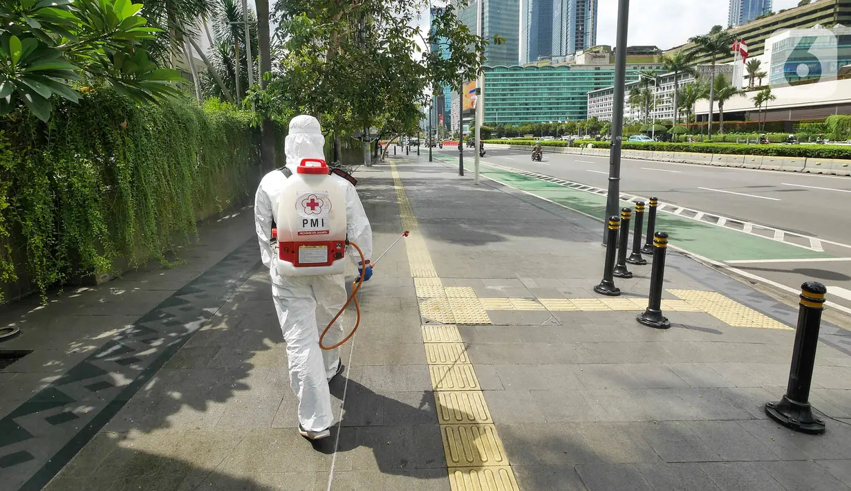 Petugas PMI DKI Jakarta melakukan penyemprotan cairan disinfektan di kawasan Bundaran HI, Senin (7/2/2022). Penyemprotan disinfektan tersebut untuk sterilisasi di beberapa titik guna mencegah penyebaran COVID-19 varian omicron yang saat ini sedang mengalami peningkatan (Liputan6.com/Herman Zakharia