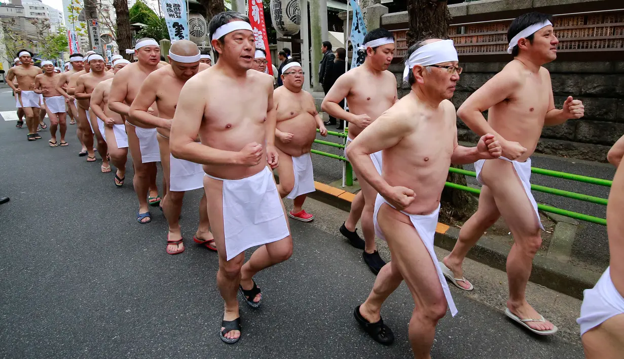 Sejumlah peserta berjalan bersama sebelum berendam di dalam kolam air dingin di Teppozu Inari Shinto Shrine di Tokyo, Jepang (8/1). Mereka percaya tradisi ini biasa dilakukan untuk membersihkan pikiran dan tubuh. (AP Photo/Shizuo Kambayashi)