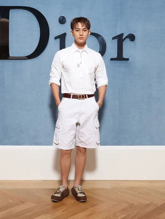 Kim Mingyu tampil berani dengan all white yang super clean. Padukan cotton polo dengan short tie dan celana pendek cargo. Ditutup dengan beige suede sneakers [Dior]
