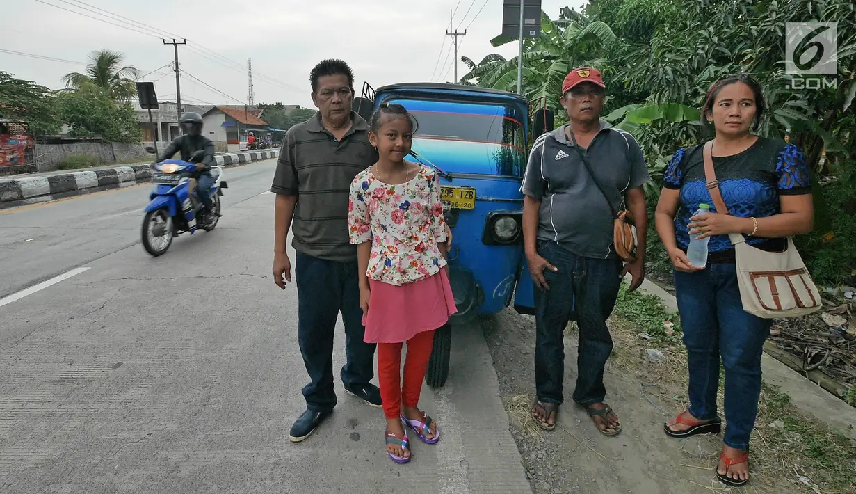 Pemudik bersama keluarganya berpose sebelum melanjutkan perjalannya di jalur pantura kawasan Patrol, Jawa Barat, Senin (3/6/2019). Keluarga ini memanfaatkan bajajnya sebagai angkutan mudik dari Jakarta menuju kampung halamannya di Cirebon, Jawa Tengah. (Liputan6.com/Herman Zakharia)