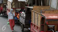 Warga melintas di sisi motor gerobak sampah di Tempat Pembuangan Sampah Sementara Kalibata, Jakarta, Rabu (4/11/2015). Menurut warga, penumpukan sampah ini sudah terjadi sejak Senin (2/11) lalu. (Liputan6.com/Helmi Fithriansyah)