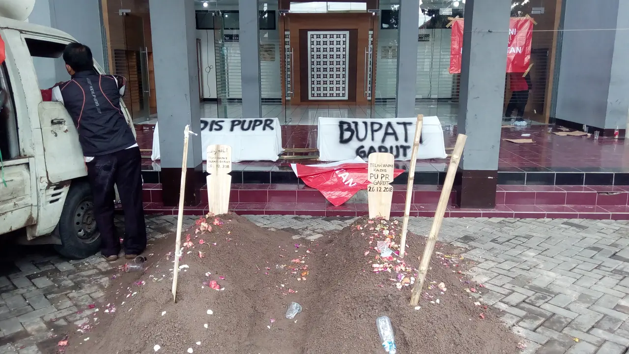 2 buah keranda dan kuburan sengaja dibuat pendemo di depan pintu masuk gedung utama DPRD Garut
