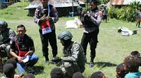 Anggota Polri tengah berbincang bincang dengan anak-anak di Papua. (Liputan6.com/Achmad Sudarno)