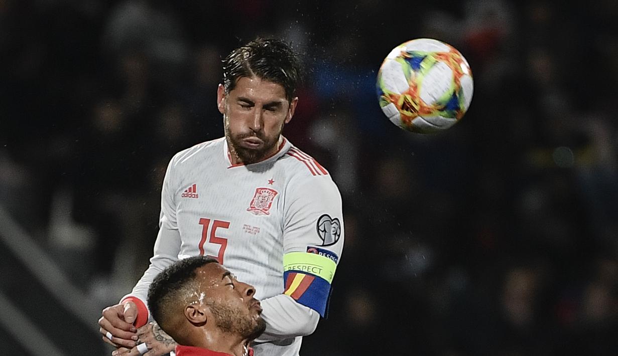 Duel udara antara Kyran Nkowo dan Sergio Ramos pada laga kedua Kualifikasi Piala Eropa 2020 yang berlangsung di Stadion Ta Qali, Malta, Rabu (27/3). Spanyol menang 2-0 atas Malta. (AFP/Filippo Monteforte)