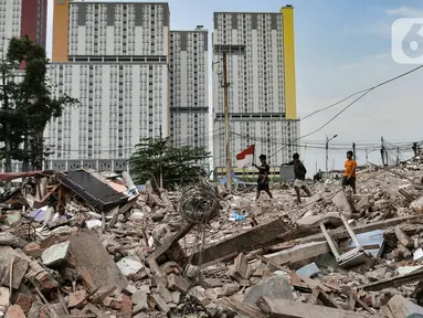 Anak-anak melintas di atas puing permukiman yang digusur di Delta Serdang, Kemayoran, Jakarta, Rabu (4/11/2020). Sebanyak 61 rumah yang dihuni sekitar 200 warga di RW 07 Delta Serdang rata dengan tanah usai digusur untuk proyek 6 Ruas Tol Dalam Kota rute Semanan-Sunter. (merdeka.com/Iqbal S Nugroho)