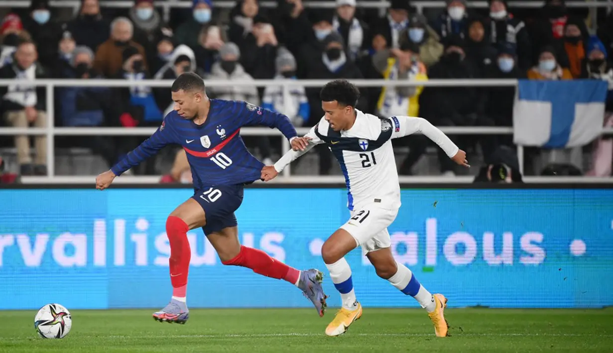 Pemain Prancis Kylian Mbappe (kiri) dan pemain Finlandia Niko Hamalainen bersaing memperebutkan bola pada pertandingan sepak bola kualifikasi Grup D Piala Dunia 2022 di Stadion Olimpiade, Helsinki, Finlandia, 16 November 2021. Prancis menang 2-0. (FRANCK FIFE/AFP)