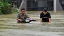 Warga mendorong sepeda motornya menerebos banjir setelah tiga hari diguyur hujan lebat di Banda Aceh, Aceh, Sabtu (9/5/2020). Banjir akibat intensitas hujan tinggi tersebut mengakibatkan sebagian besar kawasan di ibu kota Provinsi Aceh ini digenangi air. (Photo by CHAIDEER MAHYUDDIN/AFP)