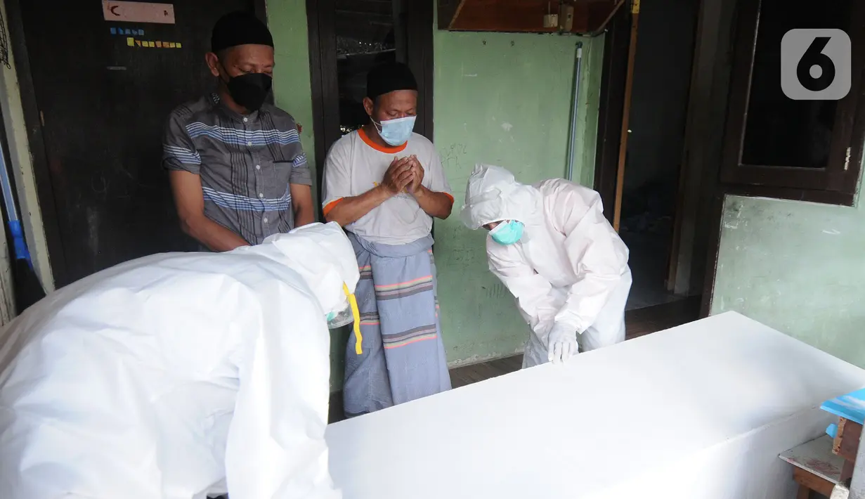 Tim relawan dari Polmas Bogor mengurus jenazah warga korban COVID-19 yang meninggal saat isolasi mandiri di Bogor, Jawa Barat, Jumat (9/7/2021). Dalam sehari, relawan menangani lima hingga delapan jenazah warga Kota Bogor yang meninggal karena COVID-19 saat isolasi mandiri. (merdeka.com/Arie Basuki)