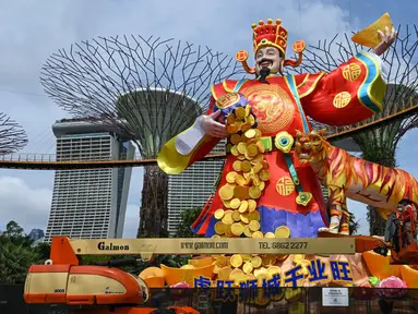 Pekerja memberikan sentuhan akhir pada patung lentera Dewa Keberuntungan untuk perayaan Tahun Baru Imlek mendatang di Gardens by the Bay Supertree Grove, Singapura, 18 Januari 2022. (Roslan RAHMAN/AFP)