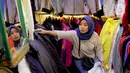 Seorang calon pembeli memilih pakaian impor bekas di Pasar Senen, Jakarta, Kamis (9/3/2023). Larangan impor baju bekas bertujuan untuk mendukung penggunaan produk lokal dan usaha kecil dan menengah milik masyarakat Indonesia. (Liputan6.com/Faizal Fanani)
