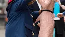 Kate Middleton asyik berdansa dengan seorang aktor yang mengenakan kostum Paddington di stasiun kereta Paddington, London, Senin (16/10). Seperti biasa, kate tampil anggun dalam balutan gaun pink salem rancangan Orla Kiely. (Jonathan Brady/Pool via AP)