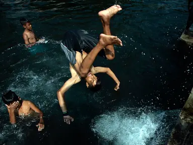 Seorang bocah melompat ke kolam pemandian Umbul Saren di Wedomartani, Sleman, Minggu (5/6). Pengunjung memadati kolam pemandian tersebut untuk melaksanakan tradisi "padusan" menjelang Ramadan 2016. (Liputan6.com/Boy Harjanto)