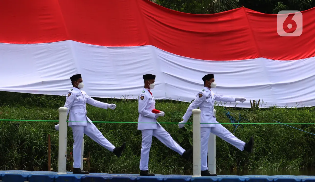 Anggota Paskibraka bersiap mengibarkan bendera merah putih di Sungai Cisadane, Kota Tangerang, Banten, Kamis (28/10/2021). Pengibaran bendera merah putih yang di ikuti puluhan pemuda tersebut di lakukan untuk memperingati hari sumpah pemuda. (Liputan6.com/Angga Yuniar)