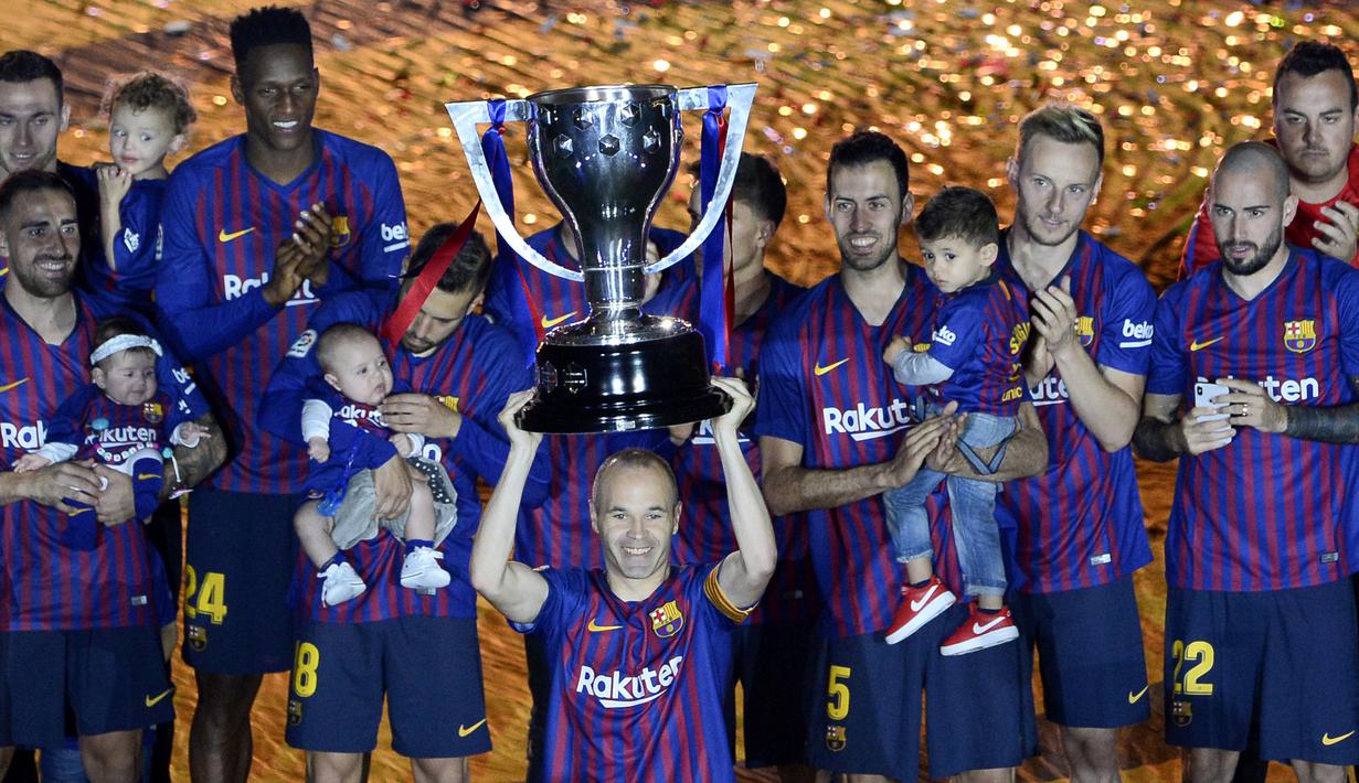 Gelandang Barcelona, Andres Iniesta, mengangkat trofi La Liga Spanyol pada momen perpisahan di Stadion Camp Nou, Barcelona, Minggu (20/5/2018). Dirinya berpisah dengan klub yang 22 tahun telah dibela. (AFP/Lluis Gene)