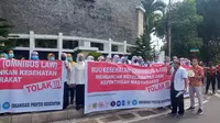 Puluhan dokter dan tenaga kesehatan yang tergabung dalam Ikatan Dokter Indonesia (IDI) Banyuwangi lakukan aksi unjuk rasa di depan Gedung DPRD Banyuwangi Tolak  RUU Omnibus Law Kesehatan (Hermawan Arifianto/Liputan6.com)