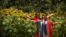Dua wanita berpose di dekat bunga matahari yang mekar di Olympic Forest Park, Beijing, China (10/7). Pihak berwenang mengeluarkan peringatan gelombang panas yang diperkirakan melonjak di atas 95 derajat (35 C ). (AP Photo/Mark Schiefelbein)