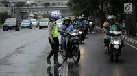 Polisi melakukan tindakan tilang kepada pengendara motor yang melanggar aturan jalur khusus sepeda motor di Jalan MH Thamrin, Jakarta, Kamis (8/2). Pengendara yang melanggar, ditilang dengan denda maksimal Rp 500 ribu. (Liputan6.com/Arya Manggala)