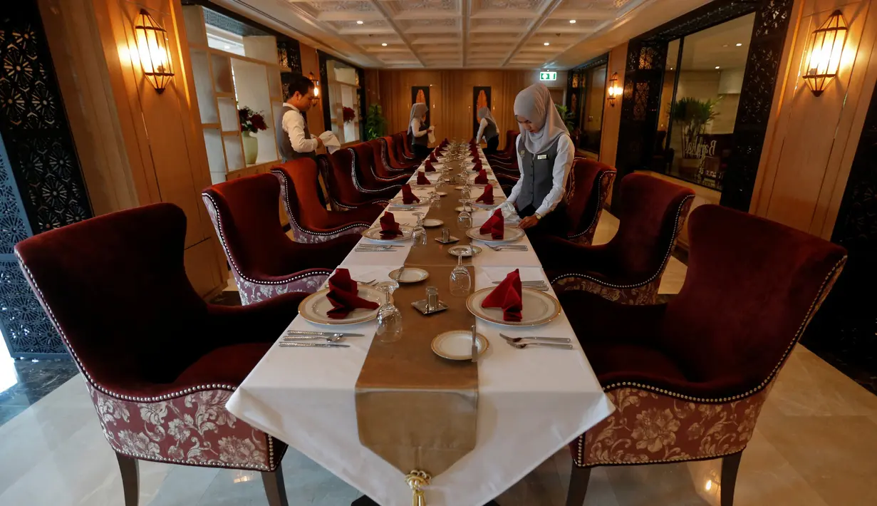Sejumlah pekerja muslim menyiapkan meja makan di hotel Al Meroz, Bangkok, (29/8). Hotel halal pertama di Thailand itu bertarif antara US$116 hingga US$1.445 per malam atau Rp1,5 juta hingga Rp19 juta. (REUTERS/Chaiwat Subprasom)