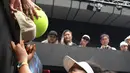 Petenis Jepang Naomi Osaka menandatangani topi yang disodorkan penonton usai mengalahkan petenis Republik Ceko Marie Bouzkova pada Australia Terbuka di Melbourne, Australia, Senin (20/1/2020). Penonton menyodorkan topi, bendera, hingga bola untuk ditandatangani Naomi. (AP Photo/Andy Brownbill)