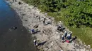 Sejumlah nelayan, relawan, dan anggota LSM Nas Mares serta tim pelayaran Mudabala Brasil turun tangan membersihkan sampah di pantai Pulau Pombeba, Teluk Guanabara, Rio de Janeiro, Brasil. (Pablo PORCIUNCULA/AFP)
