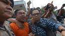 Polisi mengawal tersangka kasus penyiramanan air keras terhadap penyidik senior KPK Novel Baswedan di Polda Metro Jaya, Jakarta, Sabtu (28/12/2019). Tersangka berinisial RM dan RB dipindahkan dari Polda Metro Jaya ke Bareskrim Mabes Polri untuk penyidikan lebih lanjut. (merdeka.com/Imam Buhori)